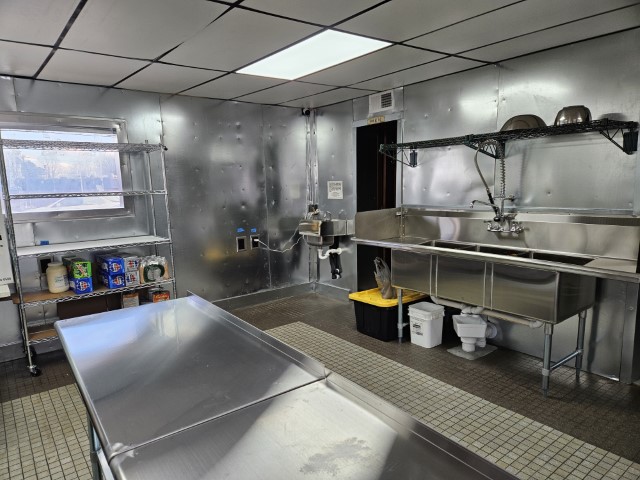 The catering kitchen's three-compartment prep sink and handwashing sink.